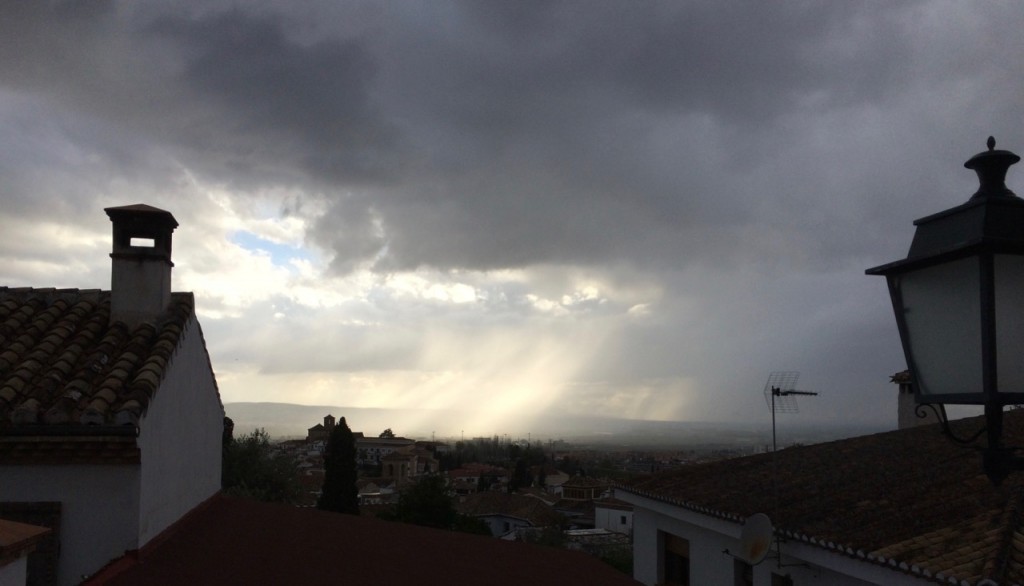 The sun breaks through the clouds over Granada